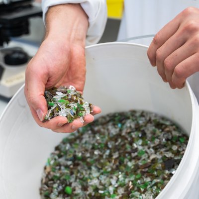 A bucket of mixed colour broken glass which can be used in the process.